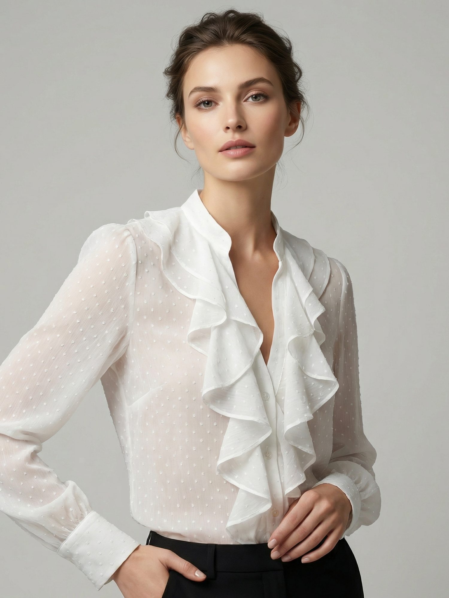 Mujer vistiendo blusa blanca elegante con volantes y tejido plumeti sobre fondo gris